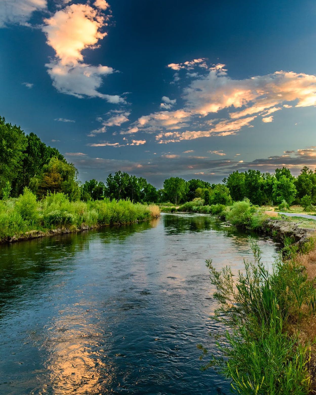 Body of Water and Green Field Under Blue Sky Photo by Matthew Montrone